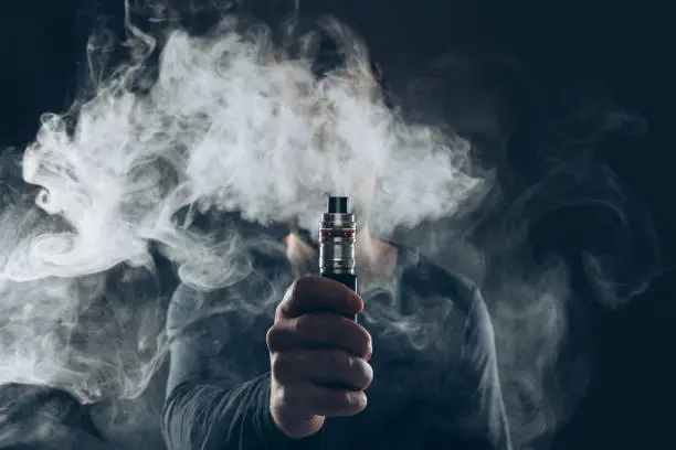 quelqu'un qui fume une cigarette électronique