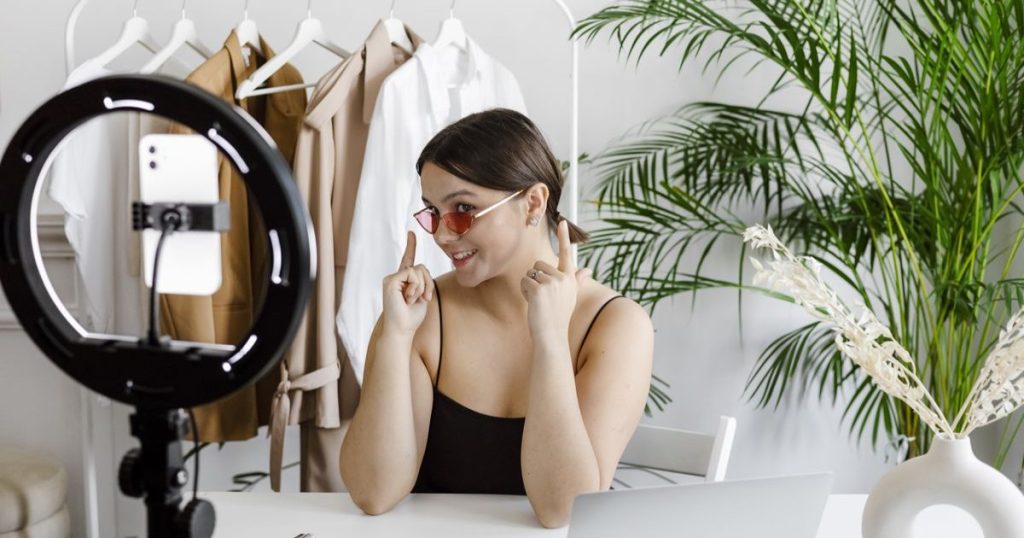 Influenceuse en train de poser pour un partenariat rémunéré de lunettes de soleil.