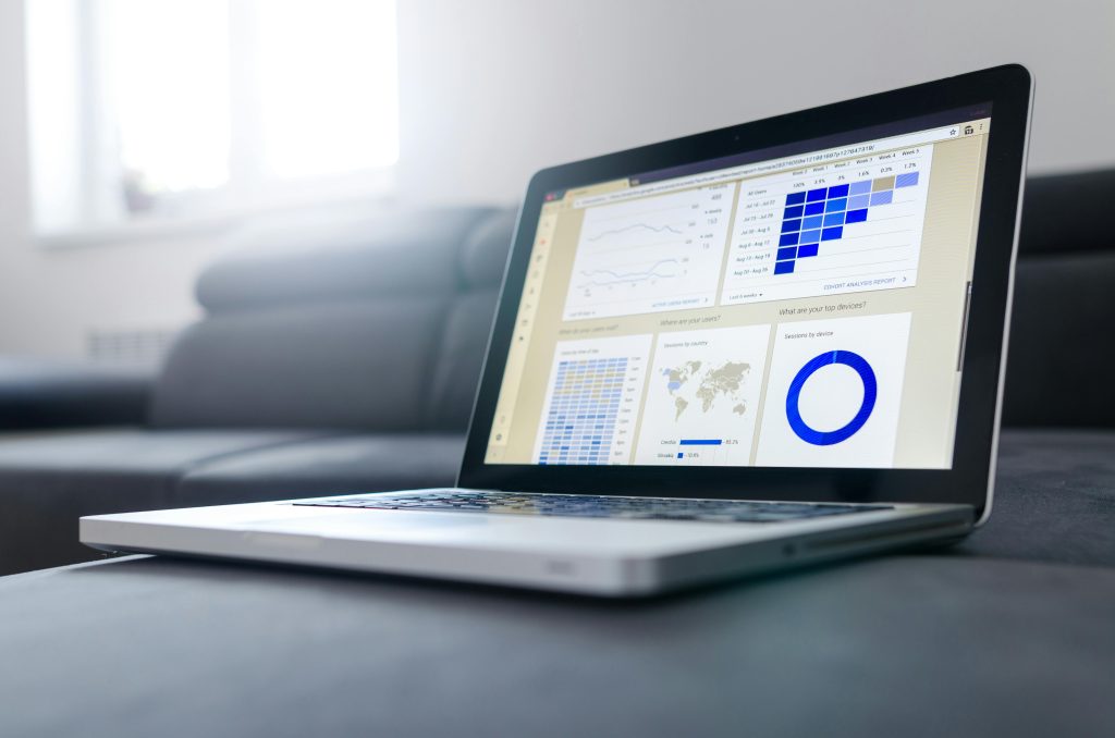 Ordinateur sur un bureau affichant des graphiques analytiques et des données statistiques sur l'écran, représentant le suivi des performances numériques.