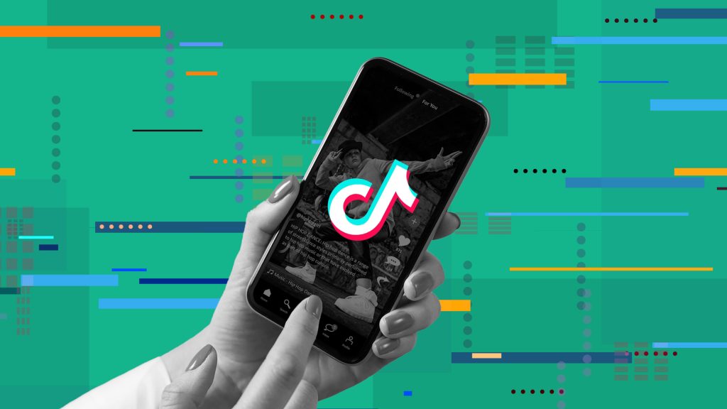 Une main tenant un téléphone avec l'application TikTok. L'utilité de l'image est de faire penser à l'algorithme de TikTok.