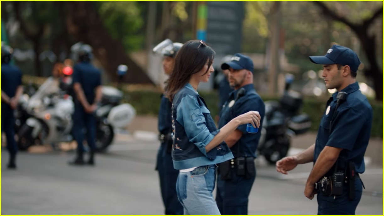 Kendall Jenner handing over a Pepsi to solve problem with police officer (marketing)