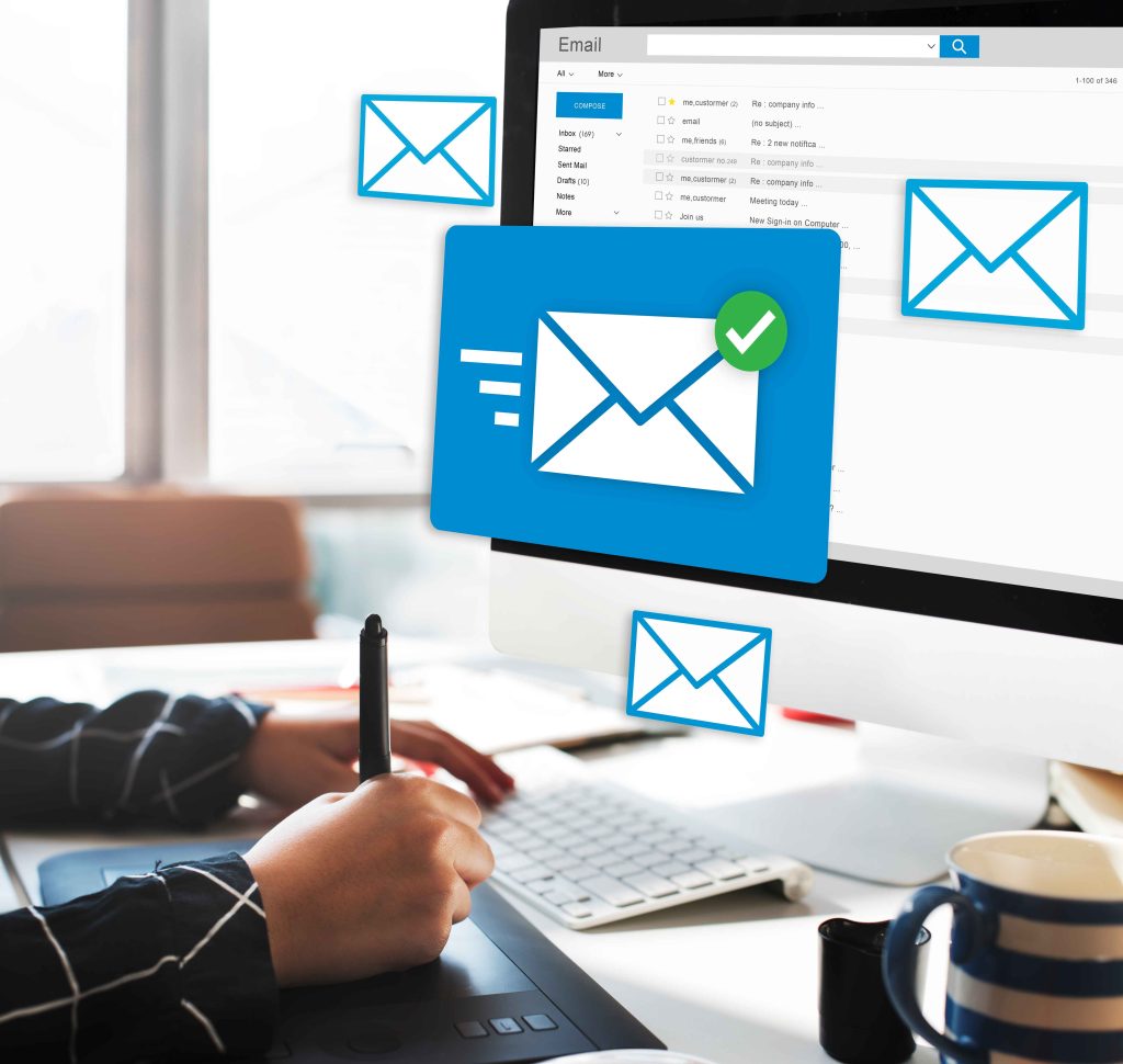 un homme assis sur sont ordinateur qui affiche des enveloppes comme des courriels comme stratégie alternative au référencement seo