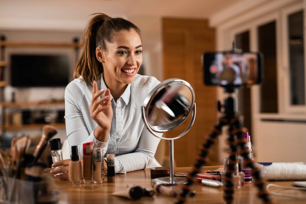 une femme présente des articles de maquillage devant la caméra (genre influenceuse) comme stratégie alternative au référencement seo
