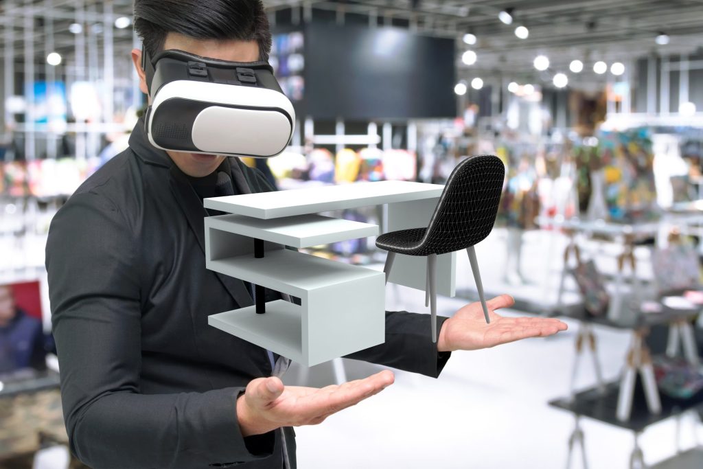 Un homme portant un casque de réalité virtuelle interagissant avec un modèle 3D de meubles, illustrant l'utilisation de la VR dans l'aménagement intérieur et le commerce.