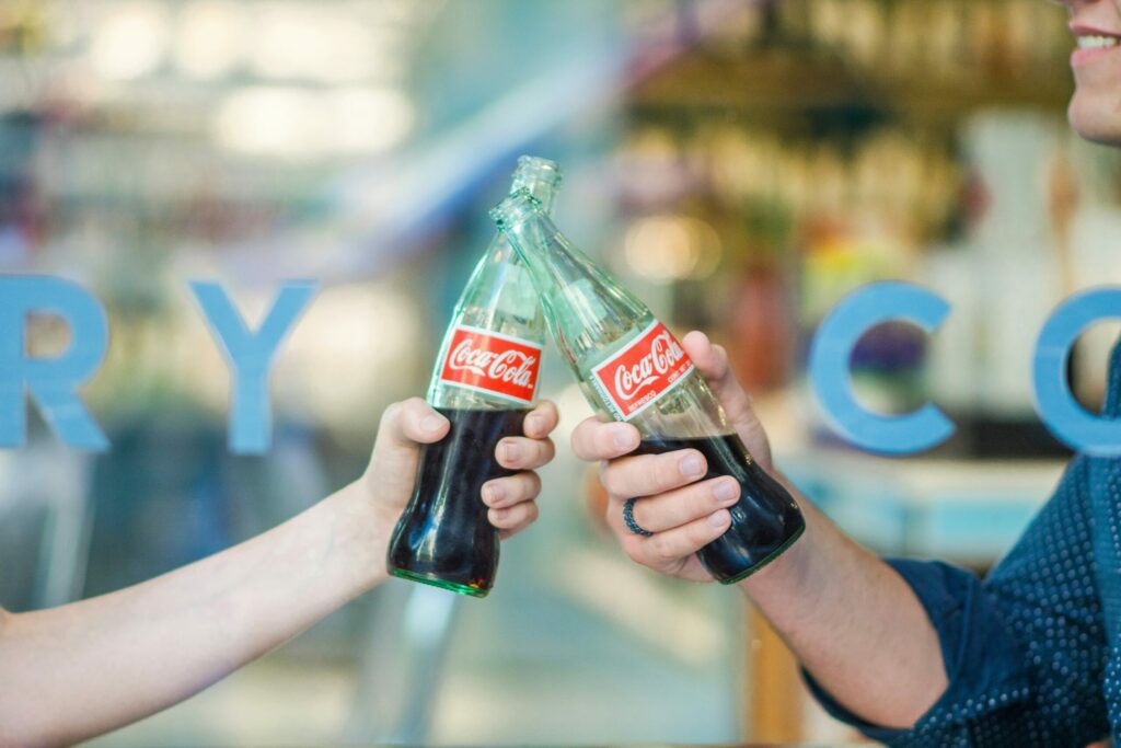 Friends sharing Coca-Cola bottles.