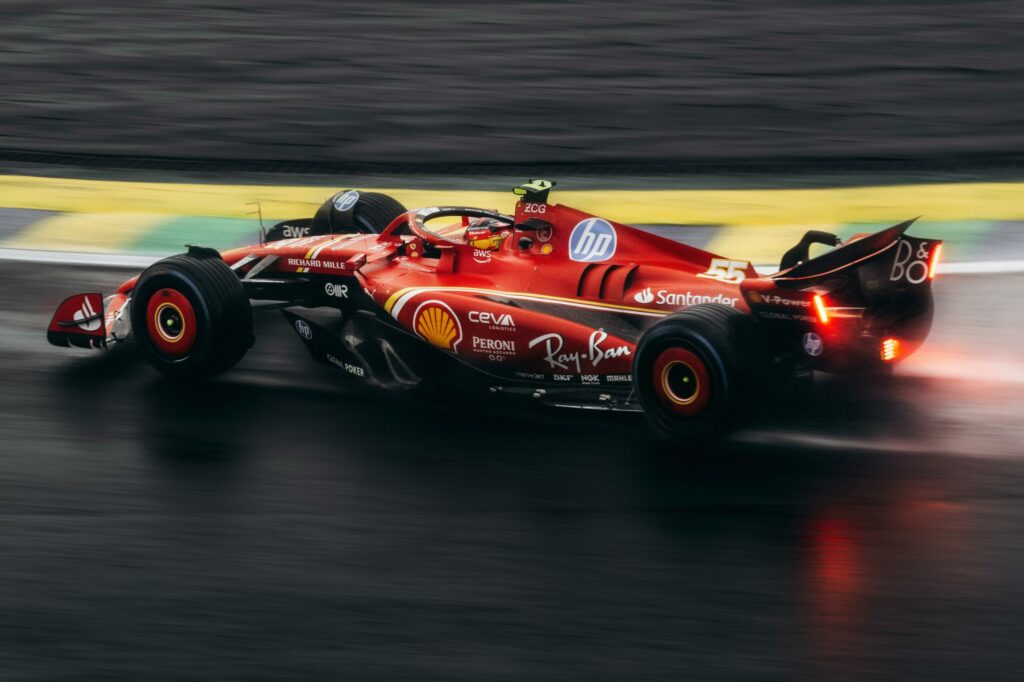 Voiture de Formule 1 Ferrari avec les logos de ses commandites comme HP, Shell et Ray-Ban, illustrant l'importance de la visibilité numérique des marques.