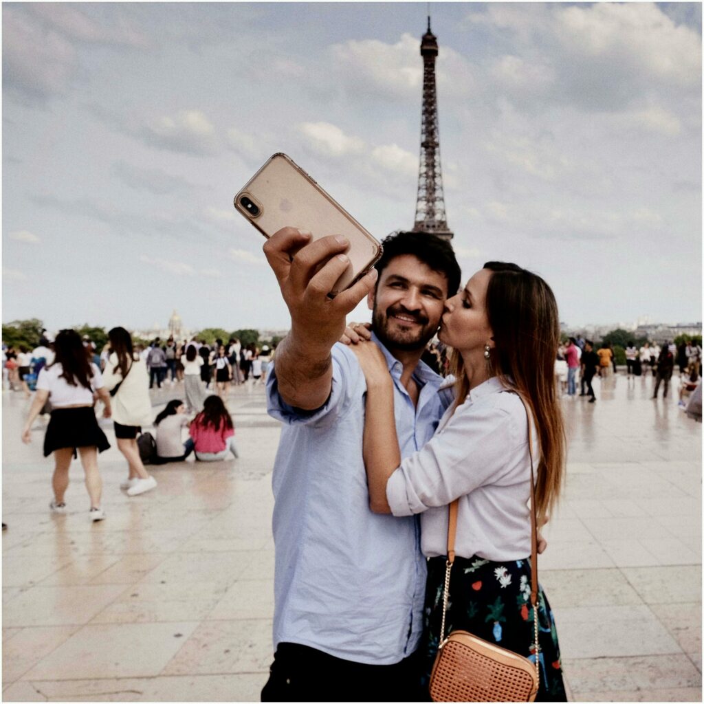 Photo libre de droits représentant un couple de touristes prenant un selfie dans une destination touristique populaire: Paris.
