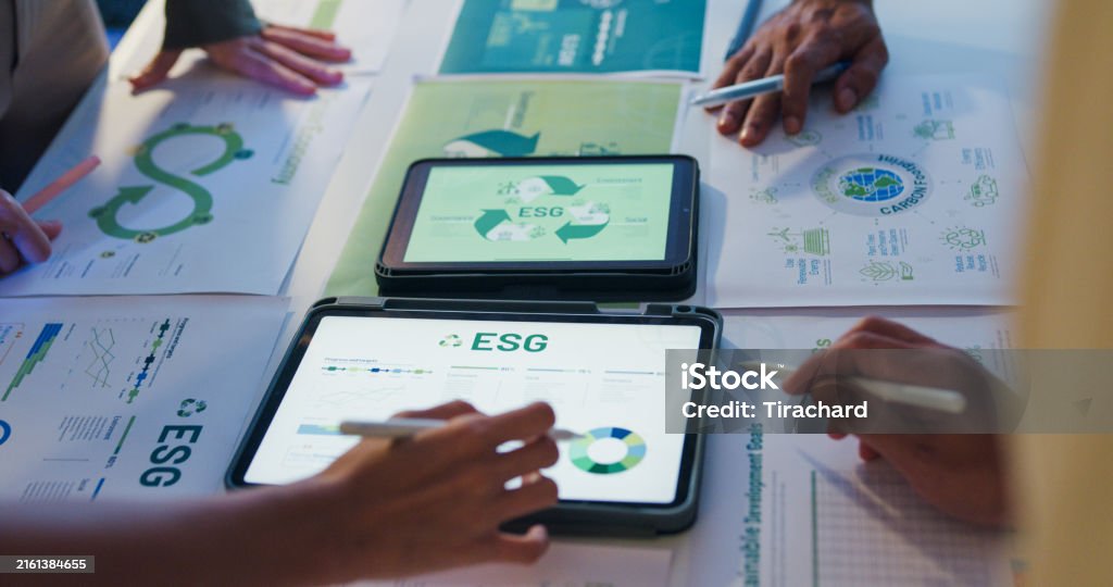 Team collaborating on tablets displaying sustainable digital marketing ESG content with green-themed visuals