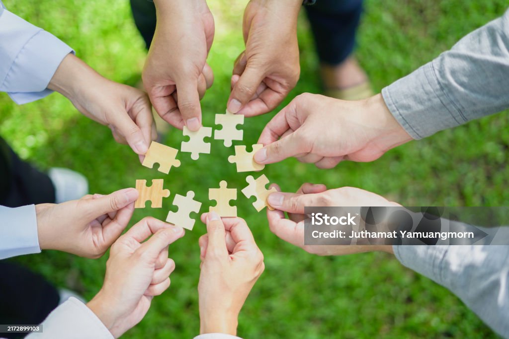 Group of people assembling puzzle pieces representing inclusion and social impact in digital marketing