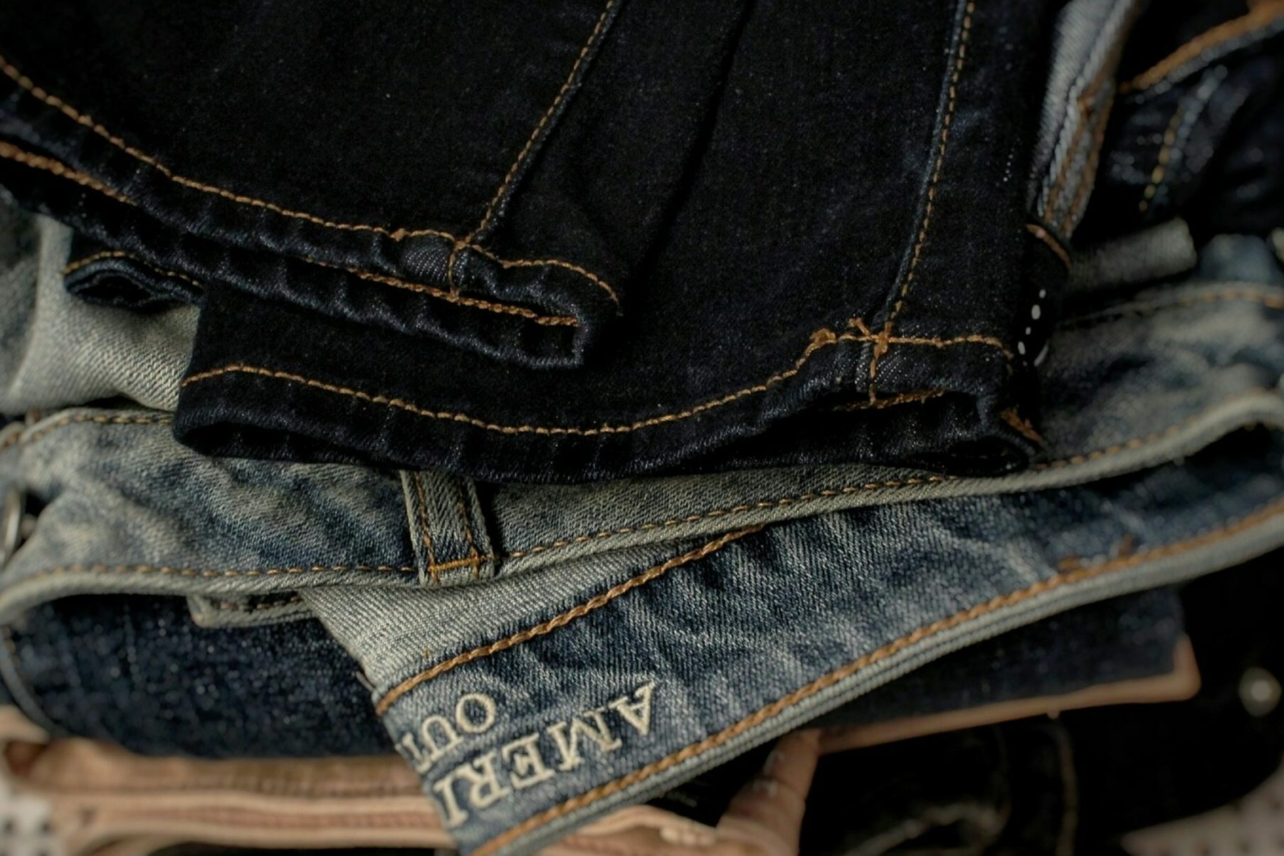 Pile of jeans on top of eachother. First one being darker jeans, the middle one being lighter jeans where we can see the "American Eagle branding" and the one at the bottom being darker jeans. Its purpose to show if the campaign was really about the jeans or to please the male gaze.