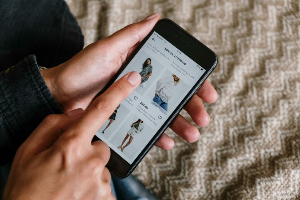Consumer browsing fashion clothing online on a smartphone after seeing items on social media promoted by influencer