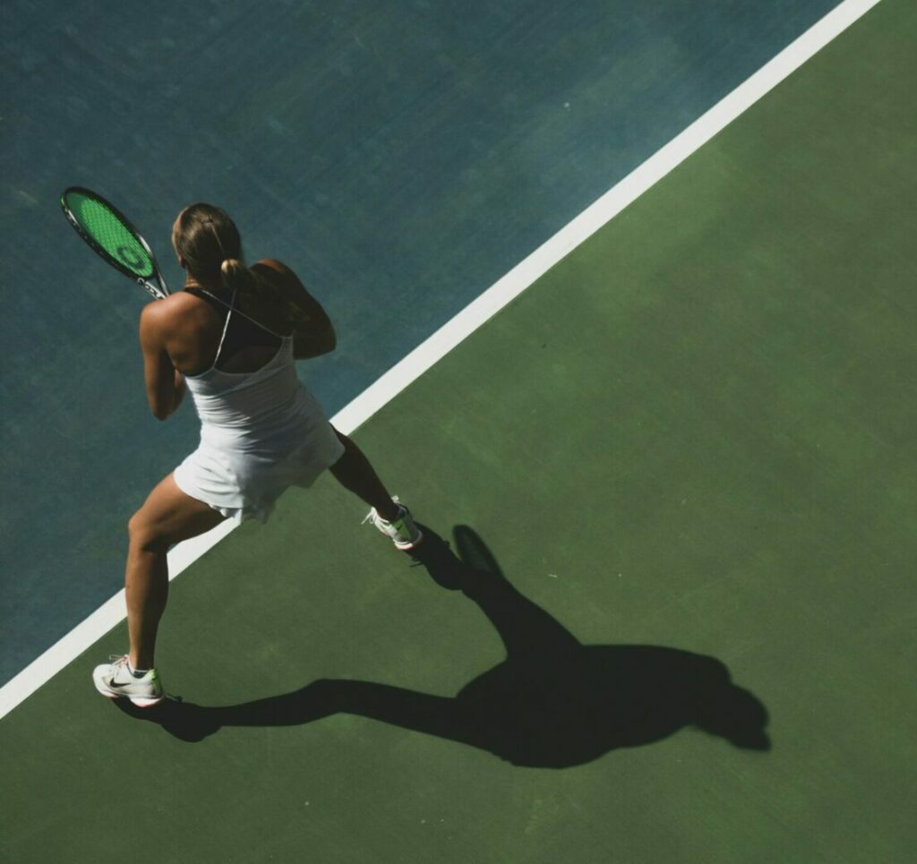 women's tennis personal branding female player serving on a green court
